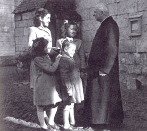 Jacqueline et Nicole (au second plan), Jeannette et Laura (au premier plan) avec le chanoine Ségelle, dans la cour du presbytère. Jacqueline et Nicole (au second plan), Jeannette et Laura (au premier plan) avec le chanoine Ségelle, dans la cour du presbytère.