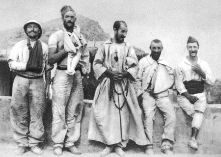 Le Père de Foucauld auprès des blessés d'El Moungar. Le Père de Foucauld auprès des blessés d'El Moungar.